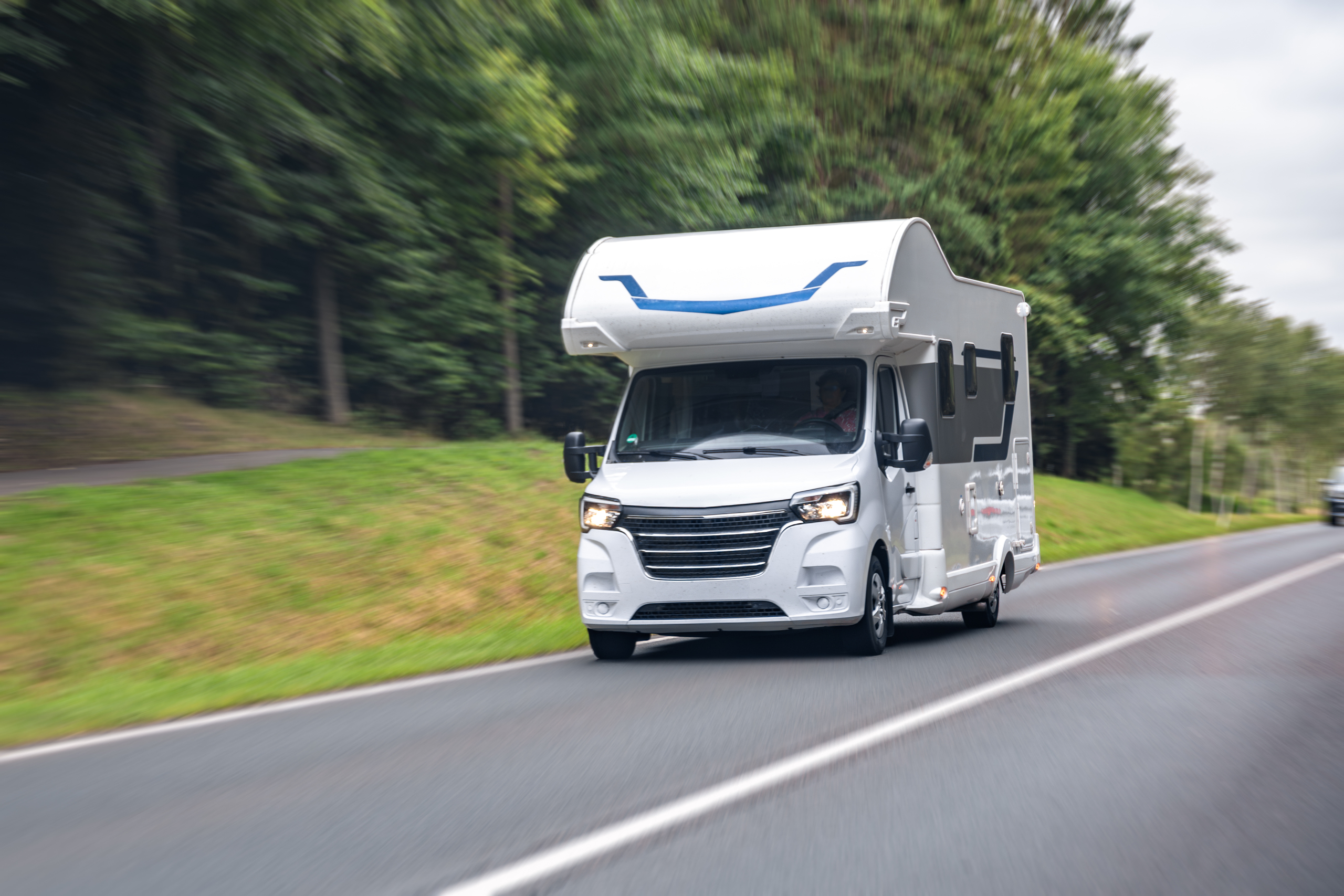 White camper van on road. Travel motion blur. Speed and freedom